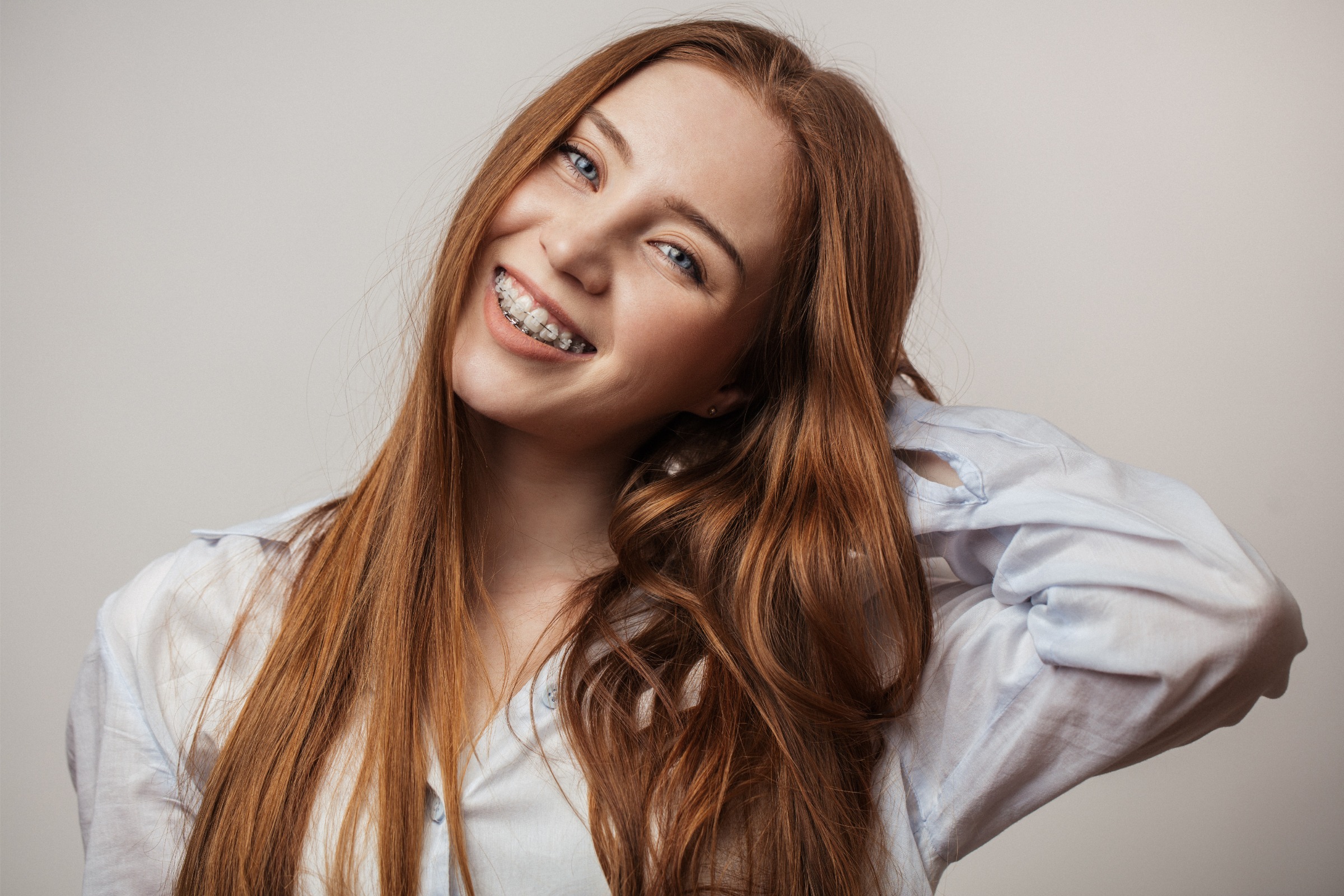 Smiling young woman with braces, showcasing orthodontic treatment, representing options like clear aligners and ceramic braces at Foley Orthodontics in Cary, NC.