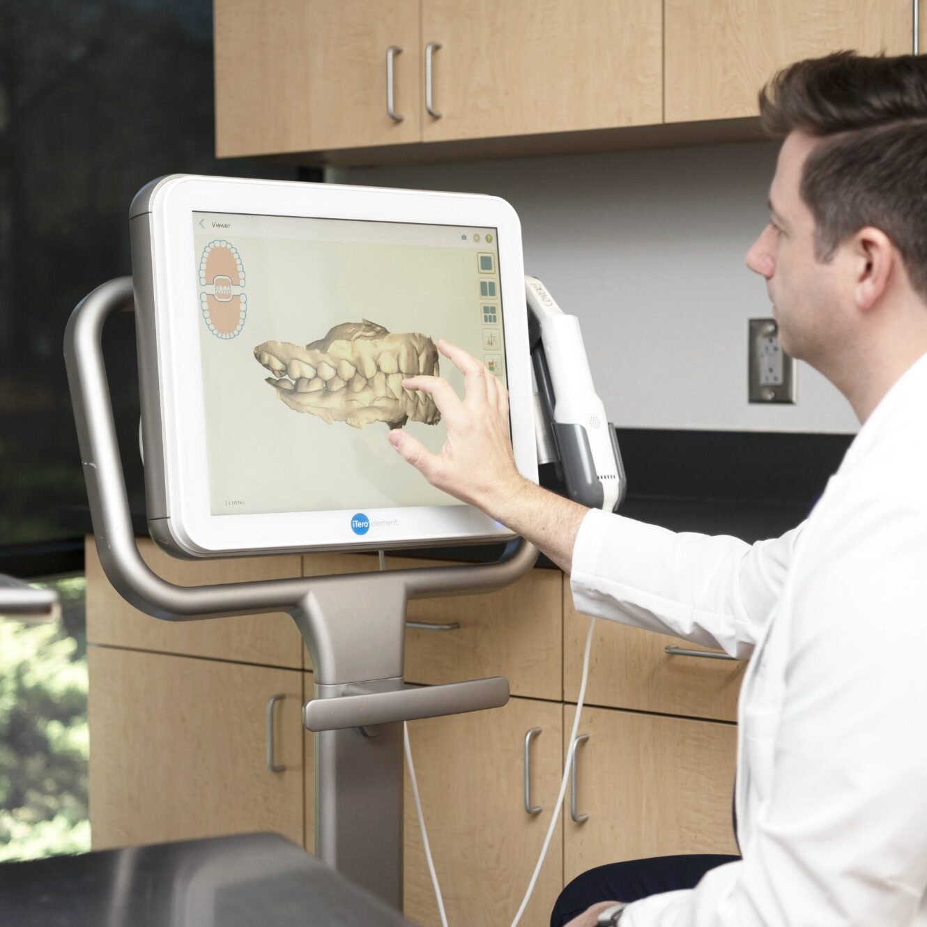 Orthodontist using advanced technology to demonstrate clear aligner treatment options on a digital screen at Foley Orthodontics in Cary, NC.